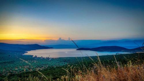 a view of a city and a lake at sunset at Goddesses Villa 1 in Nies in Soúrpi