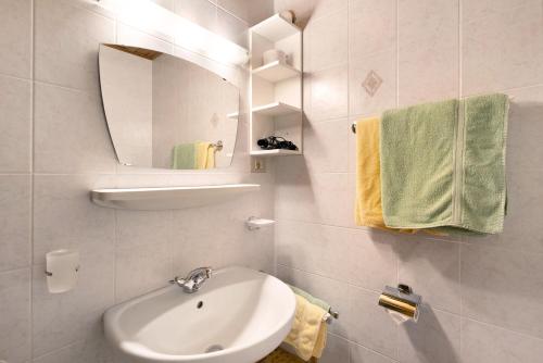 a bathroom with a sink and a mirror and towels at Bed and Breakfast Ederhof in San Giacomo