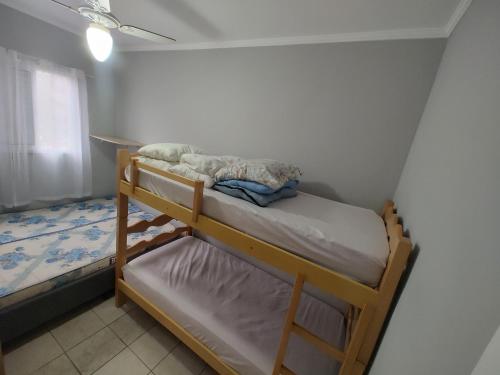 a small bedroom with two bunk beds in it at Apartamento com piscina! in Samaritá