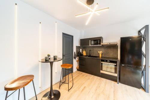 a kitchen with a stainless steel refrigerator and a table at Studio-St Pierre centre proche toutes commodités in Saint-Pierre