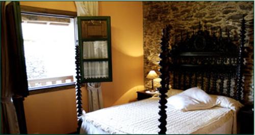 1 dormitorio con cama plegable y ventana en Casa Farruco, en Beigondo