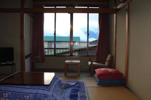 a bedroom with a large window with a view of a mountain at Sugakuso in Yamanakako