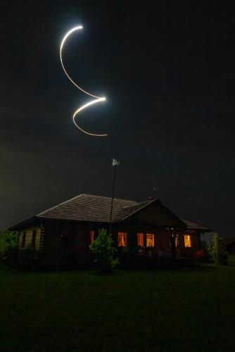 a house with a barnacly moon eclipse in the sky at Dworek Ogrodniki, całoroczny dom na wyłączność, basen, sauna, las, staw rybny, altana grillowa, ognisko, pianino, kominek, piec chlebowy, duża ogrodzona posesja in Tuczna