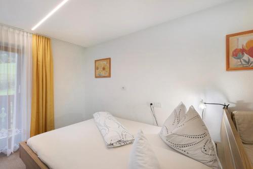 a bedroom with a white bed with white pillows at Bed and Breakfast Ederhof in San Giacomo