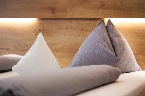 a bed with three pillows on it at Bed and Breakfast Ederhof in San Giacomo
