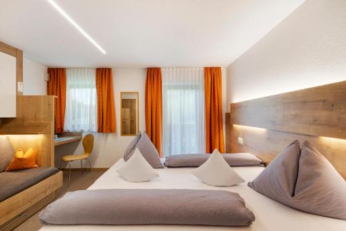 a hotel room with two beds with orange curtains at Bed and Breakfast Ederhof in San Giacomo