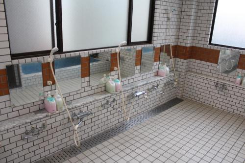 a tiled bathroom with pink and green soap bottles at Sugakuso in Yamanakako