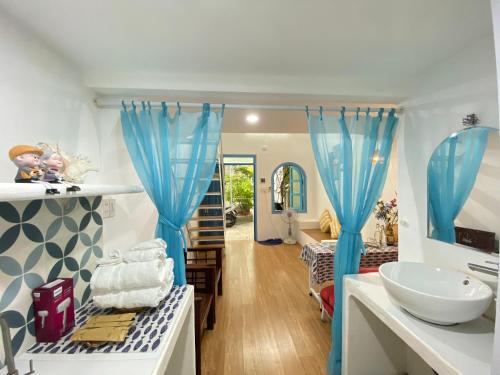 a bathroom with blue curtains and a sink at Vya homestay Huế II in Thôn Lại Thê