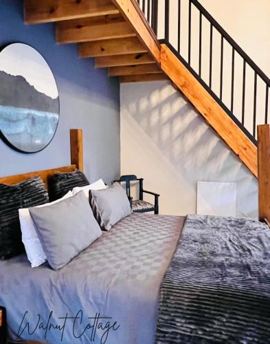 a bedroom with a large bed with a staircase at Walnut Cottage in Clarens