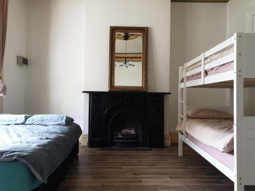 a bedroom with two bunk beds and a fireplace at Fitzroy Private Rooms - 132 Nicholson Homestay in Melbourne