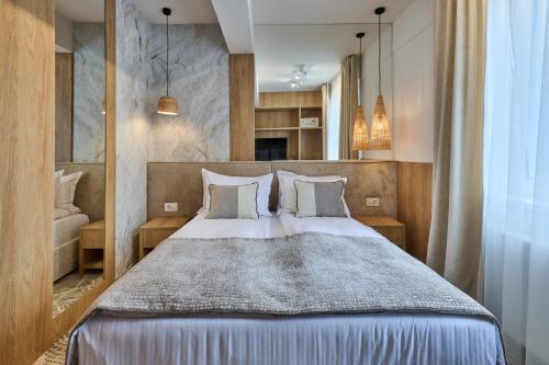 a bedroom with a large bed with two pillows at Hotel Serenity Timisoara in Timişoara