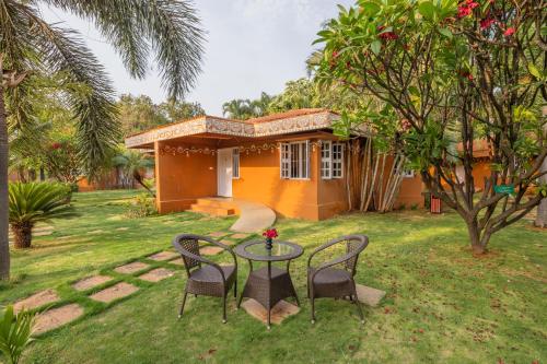 a small house with a table and chairs in the yard at Vijayshree Resort, Hampi in Hampi
