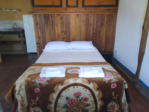a bed in a room with two towels on it at Elefante en Edén VII in Tigre