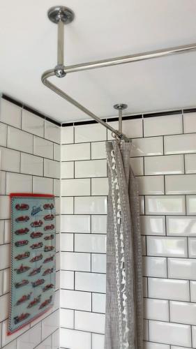 a shower curtain in a bathroom with white tiles at Greenhell Farmhouse in Nohn