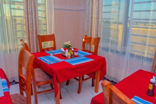 a dining room table with a red table cloth and chairs at Kamur Executive Inn in Dodoma