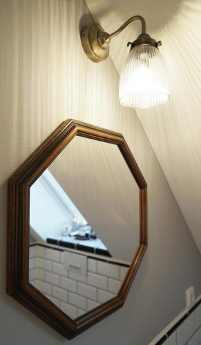 a mirror on a wall with a light and a lamp at Greenhell Farmhouse in Nohn