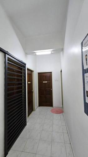 a hallway with two brown doors and a tile floor at Near USM 6 pax, 2 Bedroom w Aircond, 2 toilet, 5G WIFI in Si Dua Besar