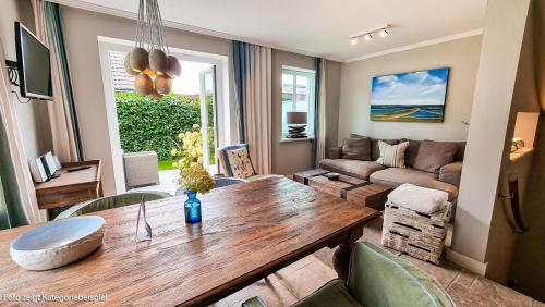 a living room with a wooden table and a couch at Hotel Hof Galerie in Morsum