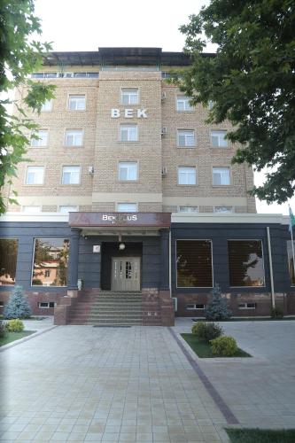a large brick building with a staircase in front of it at BEK PLUS HOTEL in Takchilik