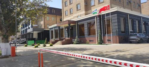 a building with a red and white curb next to a street at BEK PLUS HOTEL in Takchilik