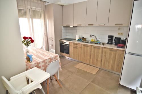 a kitchen with a table and a kitchen with white cabinets at Leonidas' privileged home in Kastoria