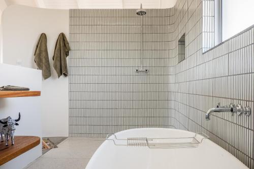Un baño blanco con bañera y ducha. en Salt Duyker Eiland, en St Helena Bay