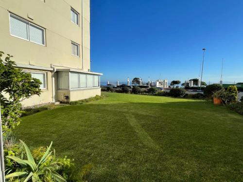 a large grassy yard next to a building at Mouille Point Villa Capri in Cape Town