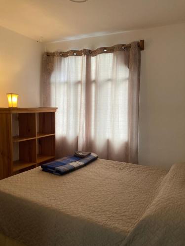 a bed in a bedroom with a window at Mandala’s Hostal in San Pedro La Laguna