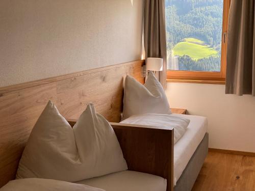 a bedroom with a bed with pillows and a window at Appartement Josef am Untersüßgut in Eben im Pongau