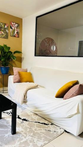 un salon avec un canapé blanc et une table dans l'établissement Cozy place near Paris, à Montigny-le-Bretonneux