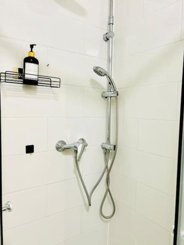 une douche avec un tuyau dans une salle de bain dans l'établissement Cozy place near Paris, à Montigny-le-Bretonneux