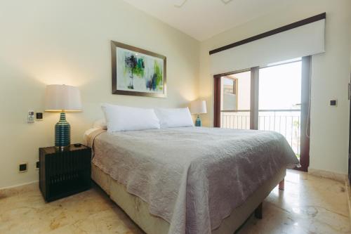 ein Schlafzimmer mit einem Bett und einem großen Fenster in der Unterkunft EL FARO 204 SURF two bedrooms apartment ocean front in Playa del Carmen