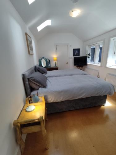 a bedroom with a large bed and a table at Spacious 2 bedroom apartment in Taunton