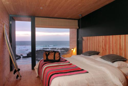 a bedroom with a bed with a view of the ocean at Hotel Apacheta in Arica