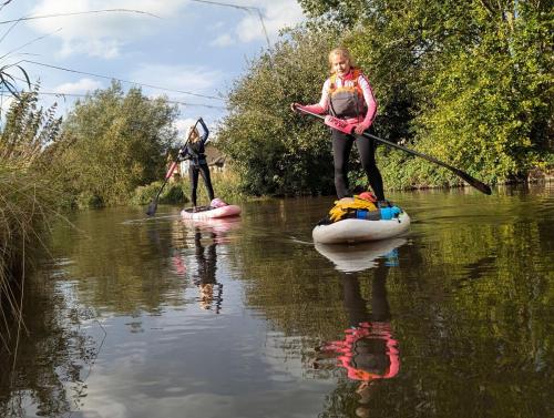 two girls are standing on rafts in a river at Alexandra place Skipton child and dog friendly in Skipton