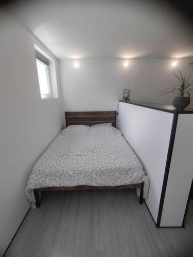 a small bedroom with a bed in the corner at Charmant studio pour 3 personnes in Briec