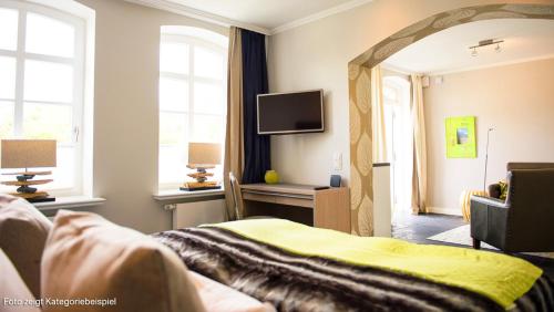 a living room with a couch and a mirror at Hotel Hof Galerie in Morsum