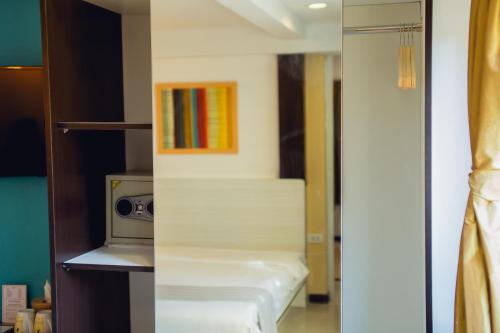 a small room with a bed and a microwave at Anchor Boutique House in Patong Beach