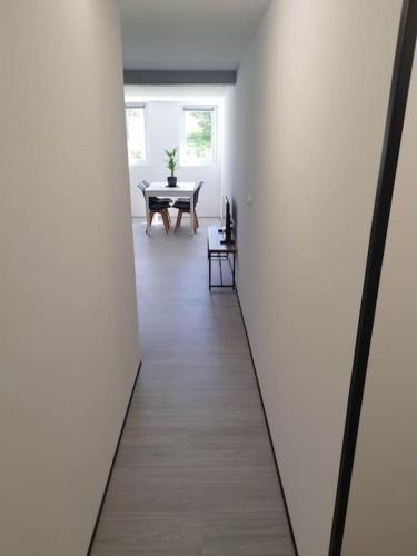 a hallway with a table in a white room at Charmant T2 flambant neuf pour 3 pers in Briec