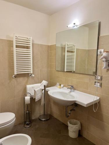 a bathroom with a sink and a toilet and a mirror at Leon Bianco in San Gimignano
