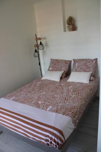 a bedroom with a large bed with brown and white sheets at COCON DES ANTILLES in Le Vauclin