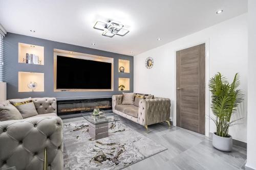 a living room with two couches and a flat screen tv at Stunning home Excellent location in Manchester