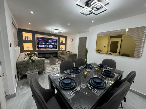 a dining room with a table and chairs and a living room at Stunning home Excellent location in Manchester