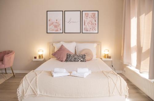 une chambre avec un lit blanc avec deux oreillers dessus dans l'établissement Le Florescence - Centre ville, à Phalsbourg