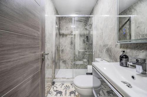a bathroom with a shower and a toilet and a sink at Stunning home Excellent location in Manchester