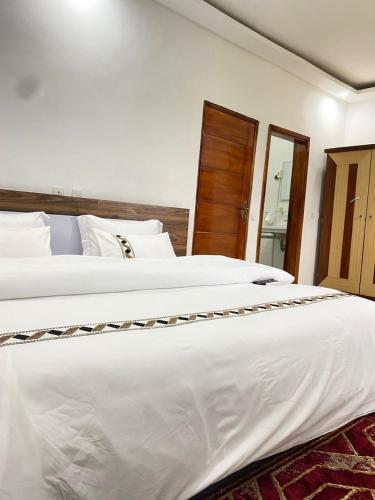 ヤムスクロにあるHotel Etoile Du Stadeのベッドルーム(白い大型ベッド2台、鏡付)