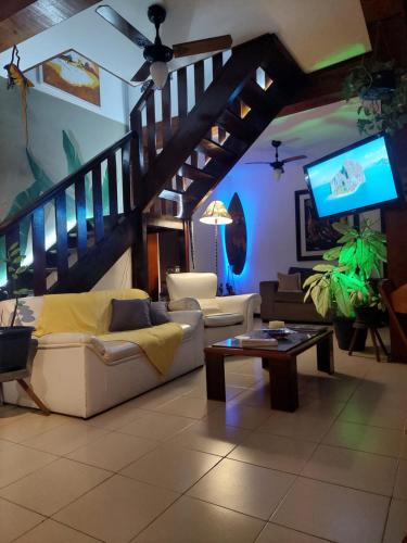 a living room with a couch and a tv at Encantos do mar in Arraial do Cabo