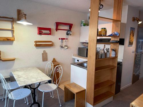 - une cuisine avec une table, une table et des chaises dans l'établissement Le Serre d Aigle, à Saint-Chaffrey