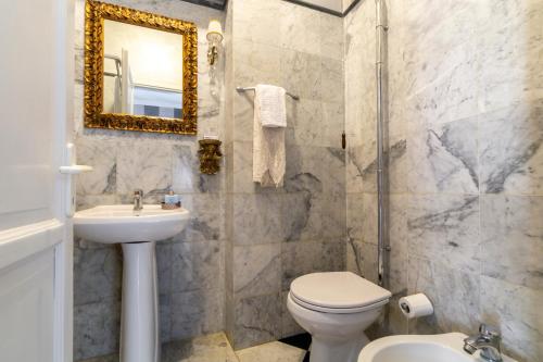 a bathroom with a toilet and a sink and a mirror at BIBI BOUTIQUE AREZZO Camere deluxe Cartazucchero & Cioccolato in Arezzo