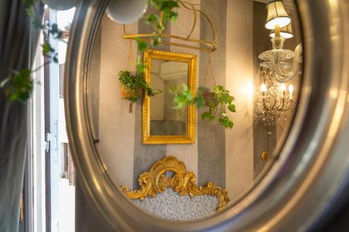 a mirror with a gold frame in a room at BIBI BOUTIQUE AREZZO Camere deluxe Cartazucchero & Cioccolato in Arezzo